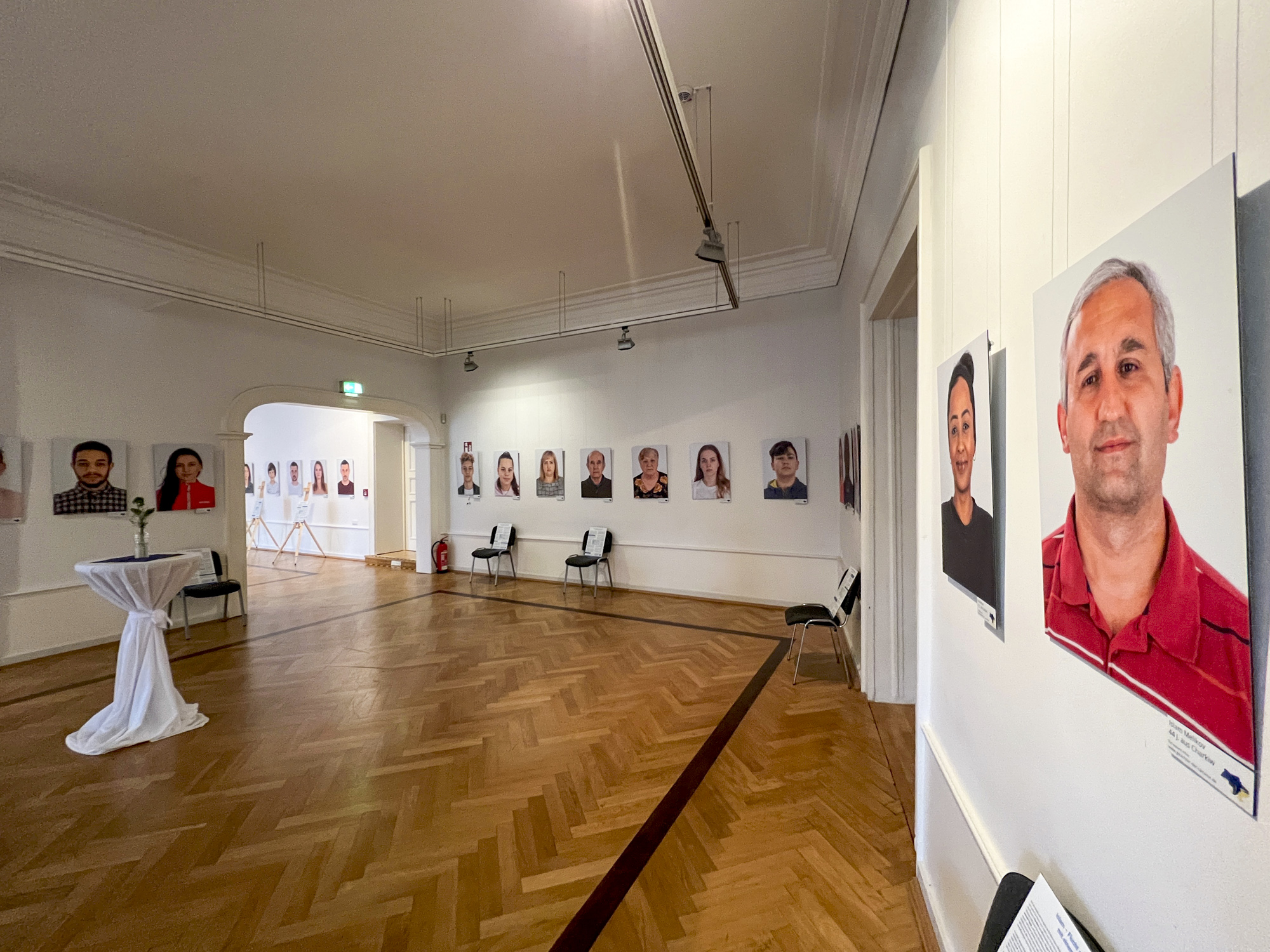 Raum mit Personenbildern an der Wand